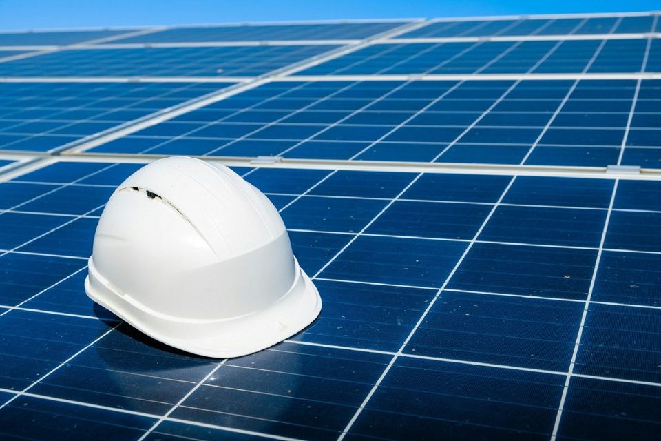 Solarmodule und Schutzhelm als Symbol für Planung und Installation